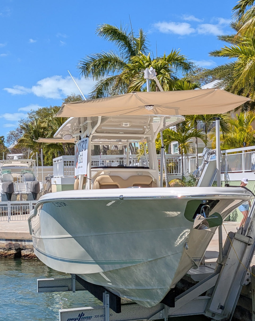 Boat on a lift with palm trees and clear sky in the background